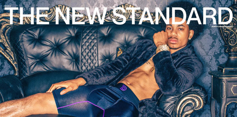 Stylish man lounging on a black chesterfield couch in Drawlz Brand Boxer Briefs and a robe