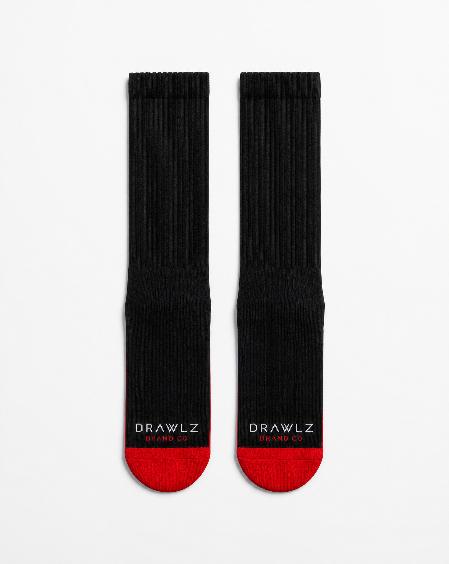 A pair of black crew socks with red toes and heels, featuring the white text 'DRAWLZ DESIGN CO.' printed on the soles, displayed against a clean white background.
